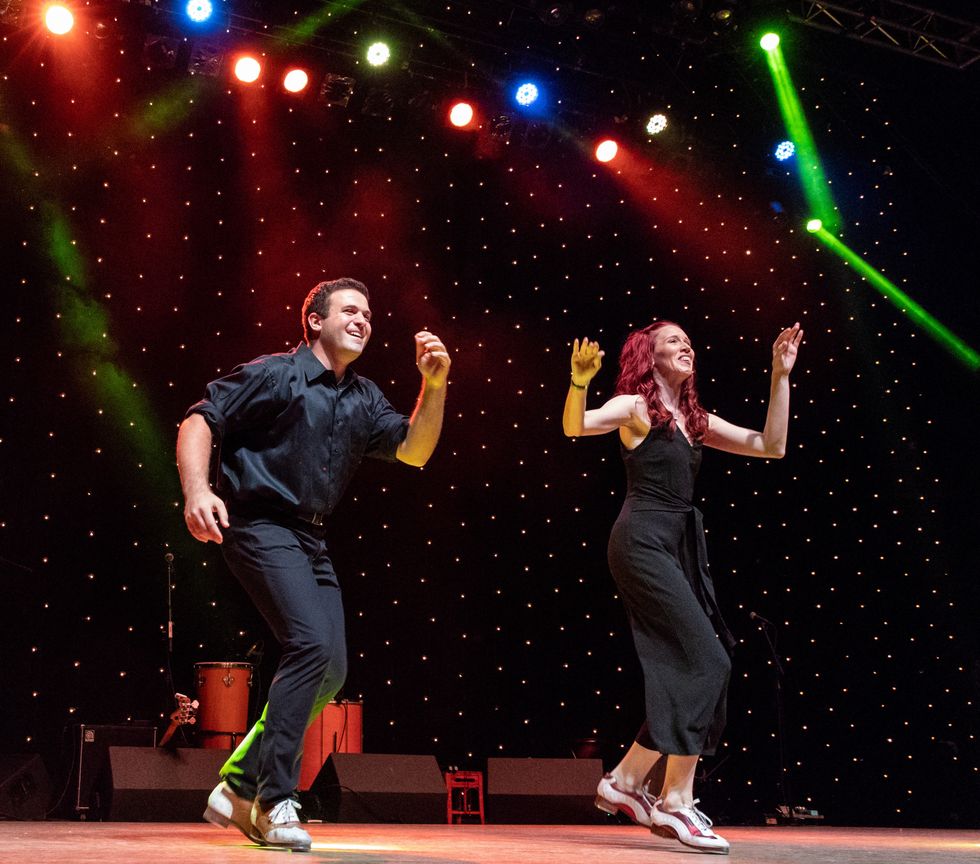 Denise Caston-Clark and Edward Tolve smile while tap dancing.