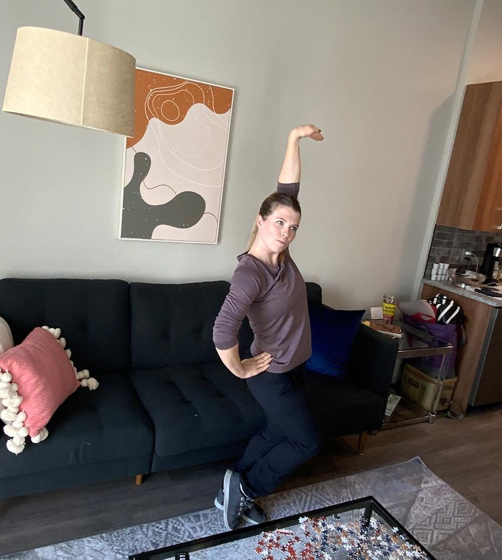 Shannon Oleson poses in a bevel in her living room, teaching a Zoom class