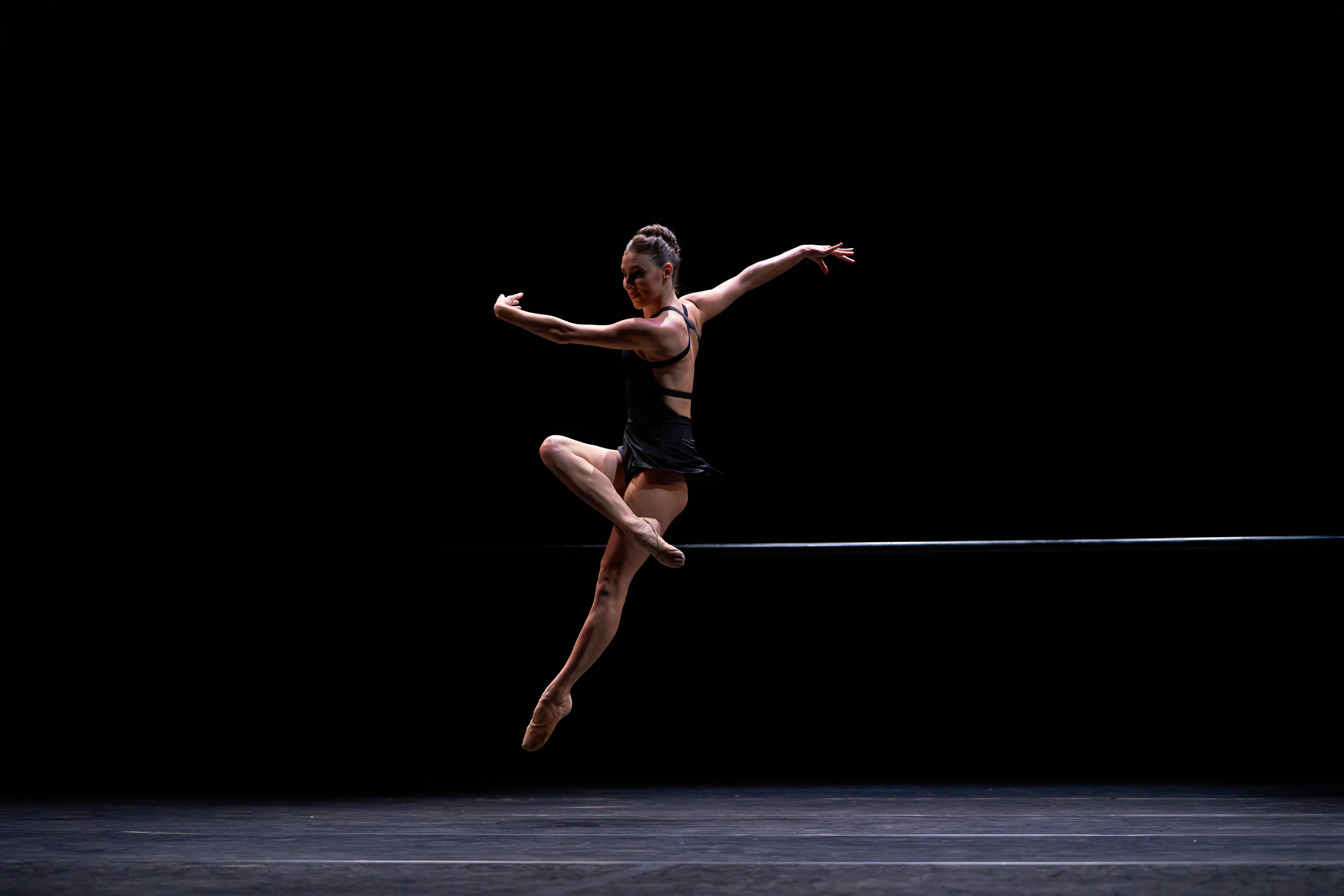 Image of ballerina Tiler Peck in a jump on stage