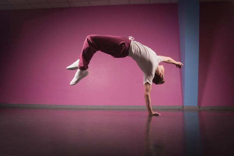 Break dancer doing handstand on one hand