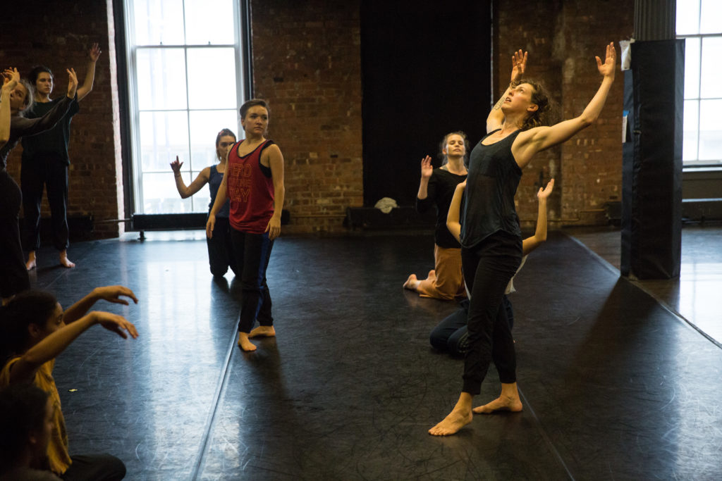 Image of a dance teacher demonstrating a movement to a class of adult students
