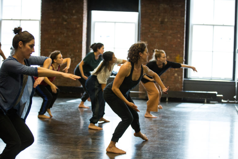 Image of a dance teacher teaching a class with adult students