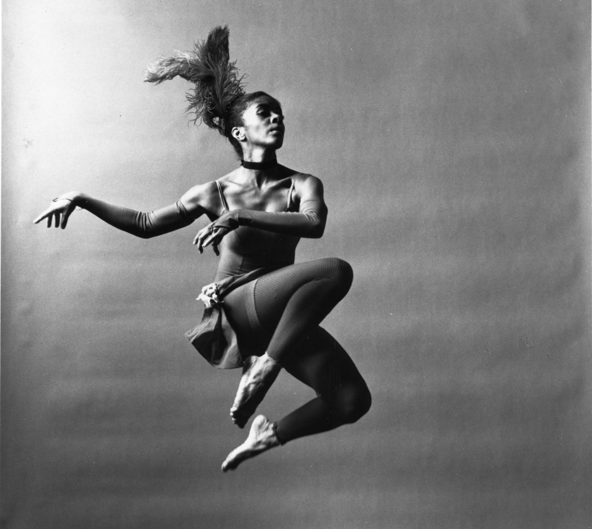 Black and white image of modern dance icon Carolyn Adams mid air in a jump
