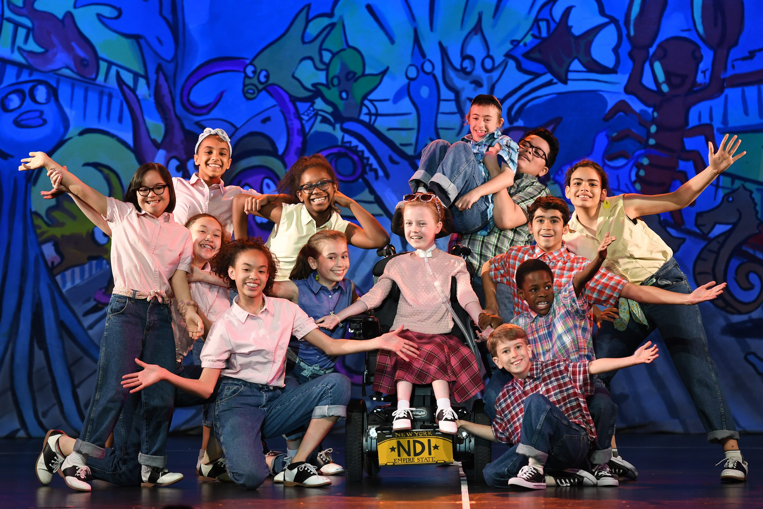 Image of children with all abilities holding a pose on stage