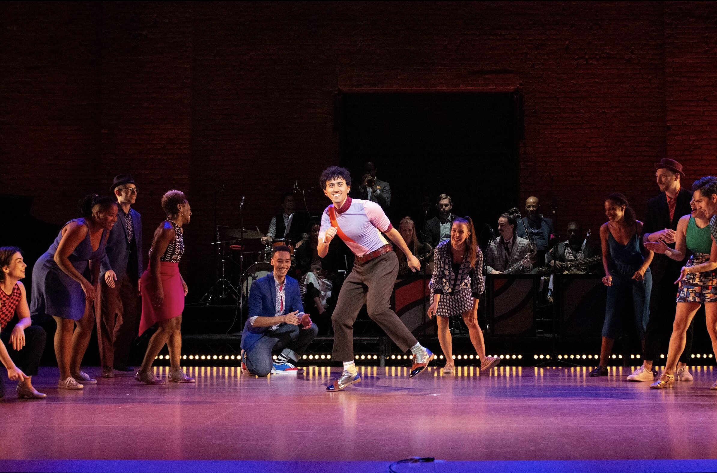 Caleb Teicher dancing on stage with dancers onlooking
