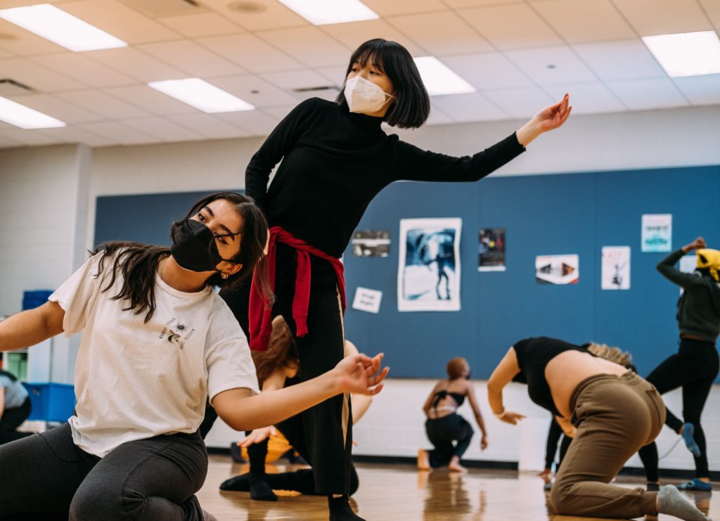 Masked dance students practicing in a studio