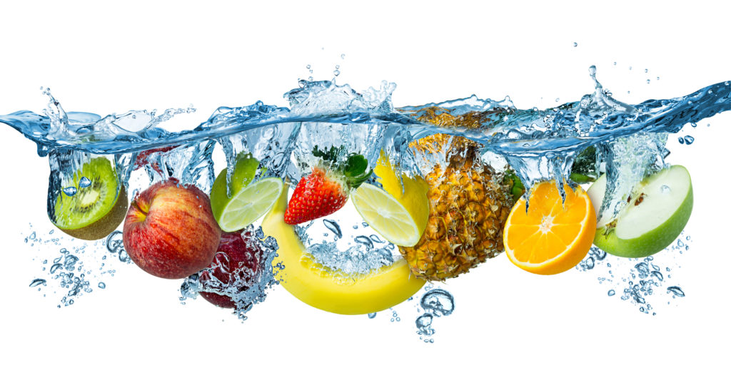 Fresh fruits splash into blue clear water against a white background.