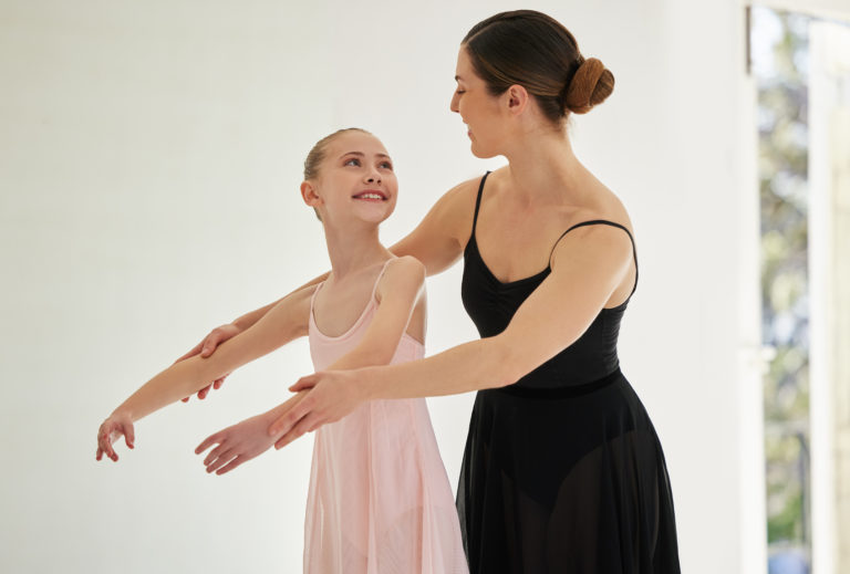 Shot of a young girl practicing ballet with her teacher in a dance studio