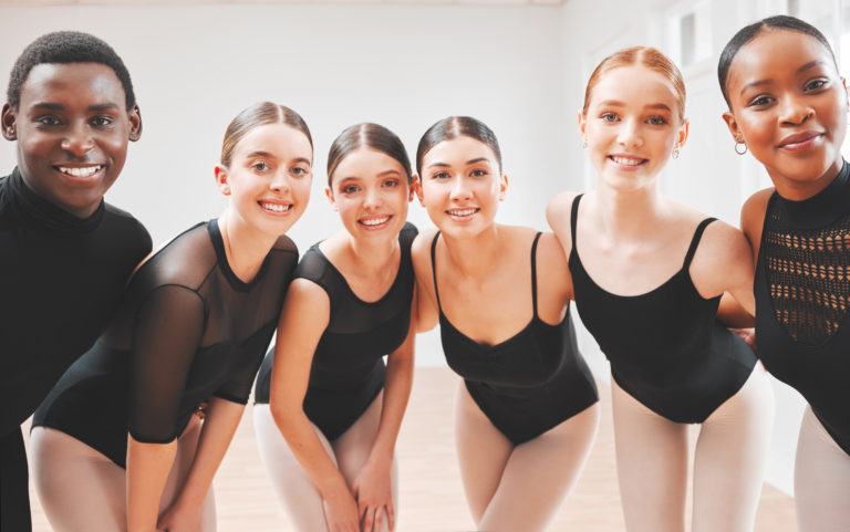 Group of young ballet dancers smiling at the camera