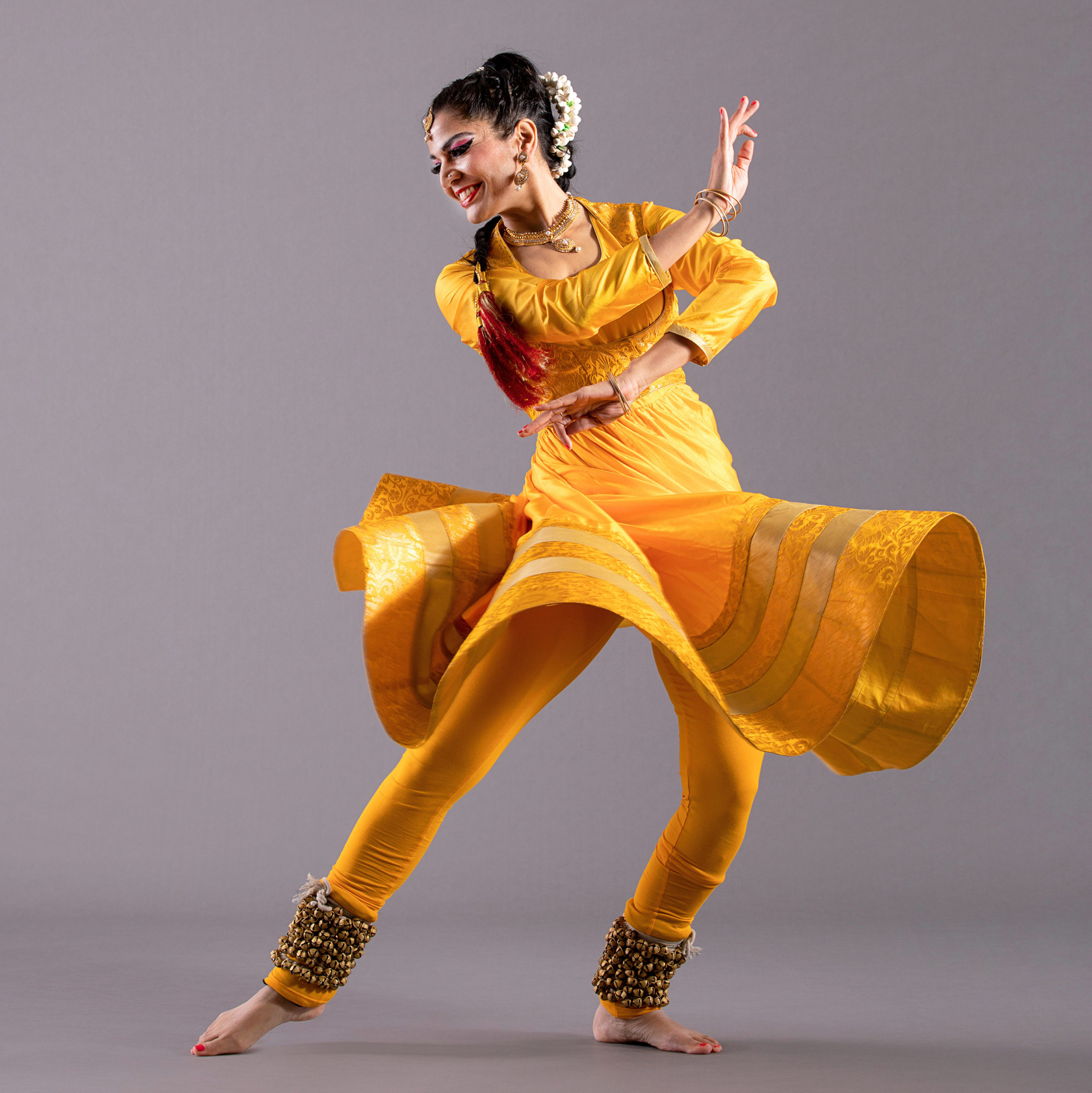 Image of dancer Rachna Nivas in a yellow Kathak costume