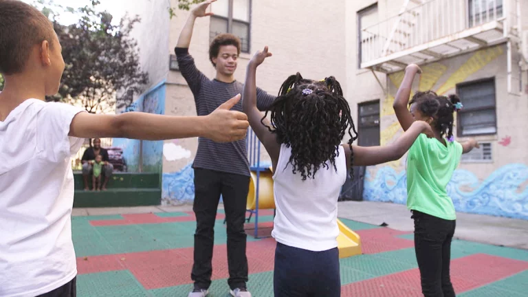 Image of dance educator with young children in an open playground