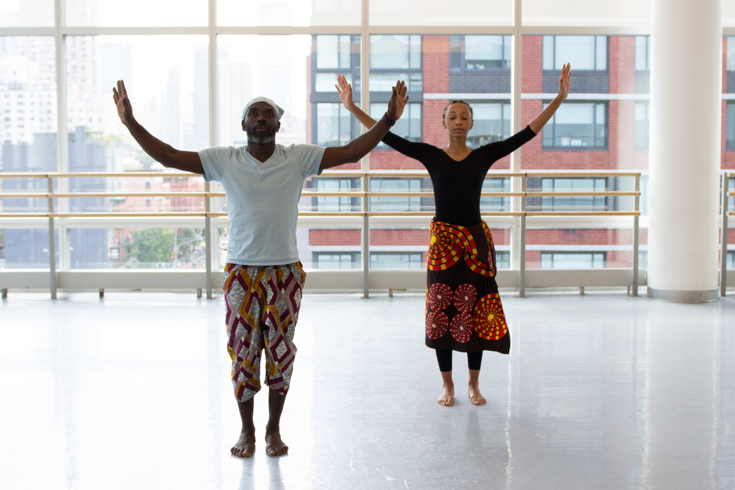 Maguette Camara teaching a student a West African dance called Lendjeng.