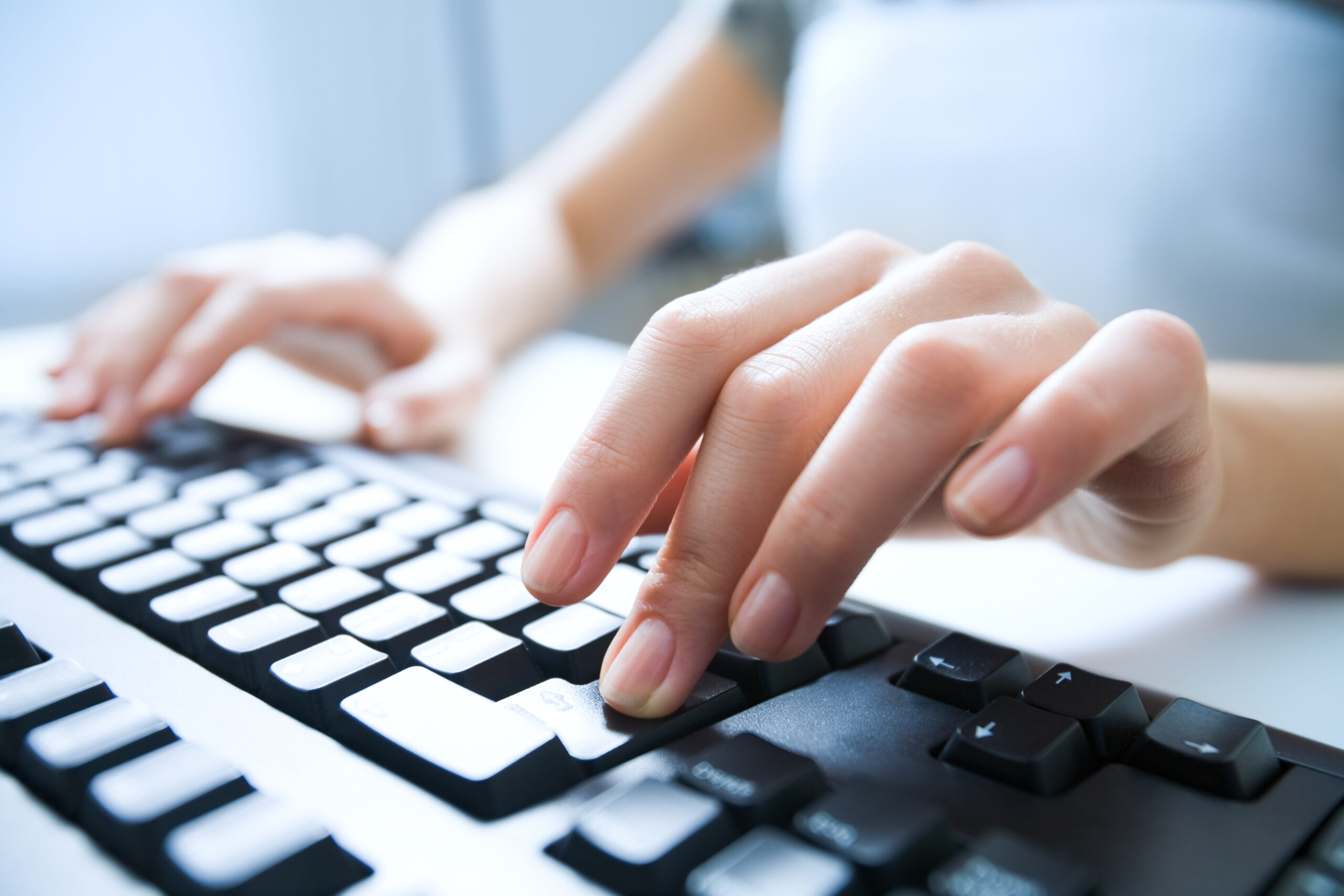 Close-up of hand pressing keys on keyboard.