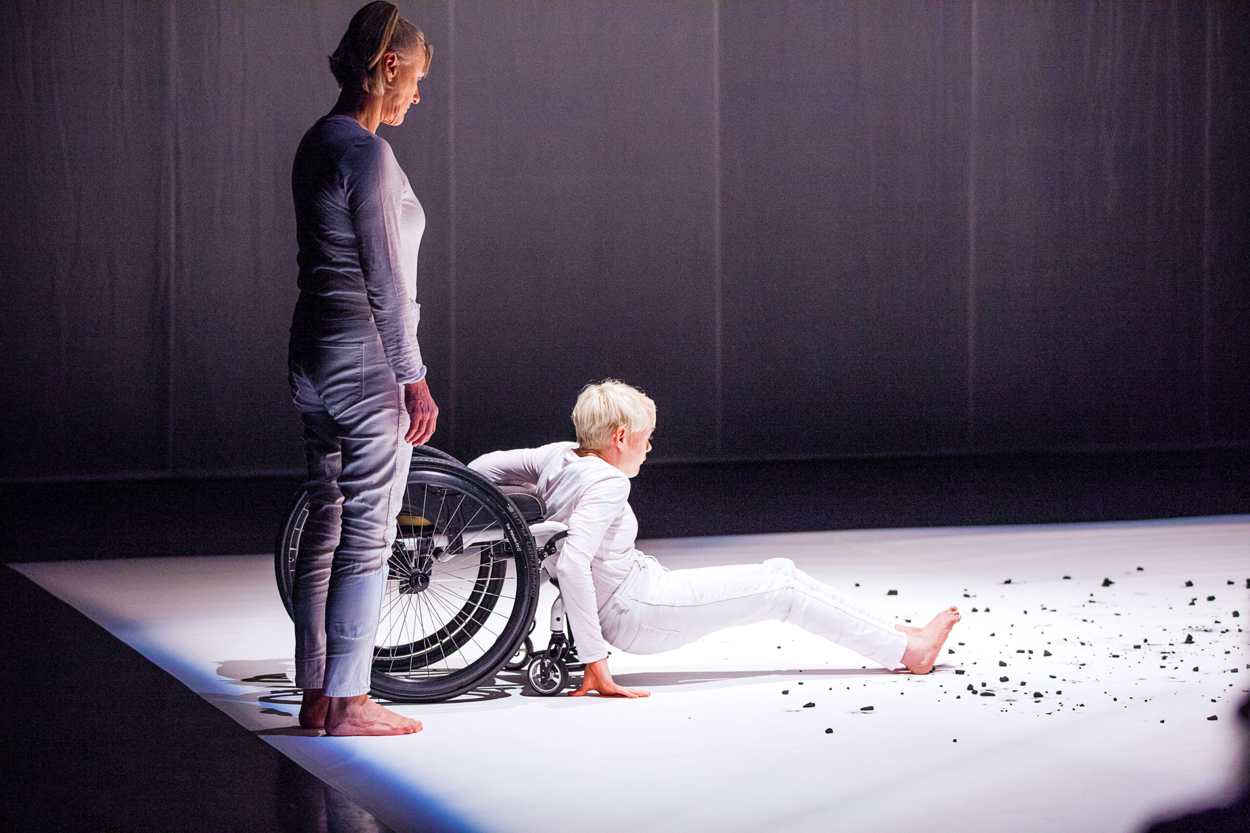 Dance educator Nina Martin with a wheelchair dancer performing on stage.