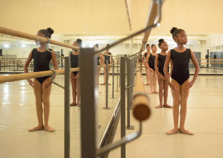 Young barre students standing in 1st position at the barre
