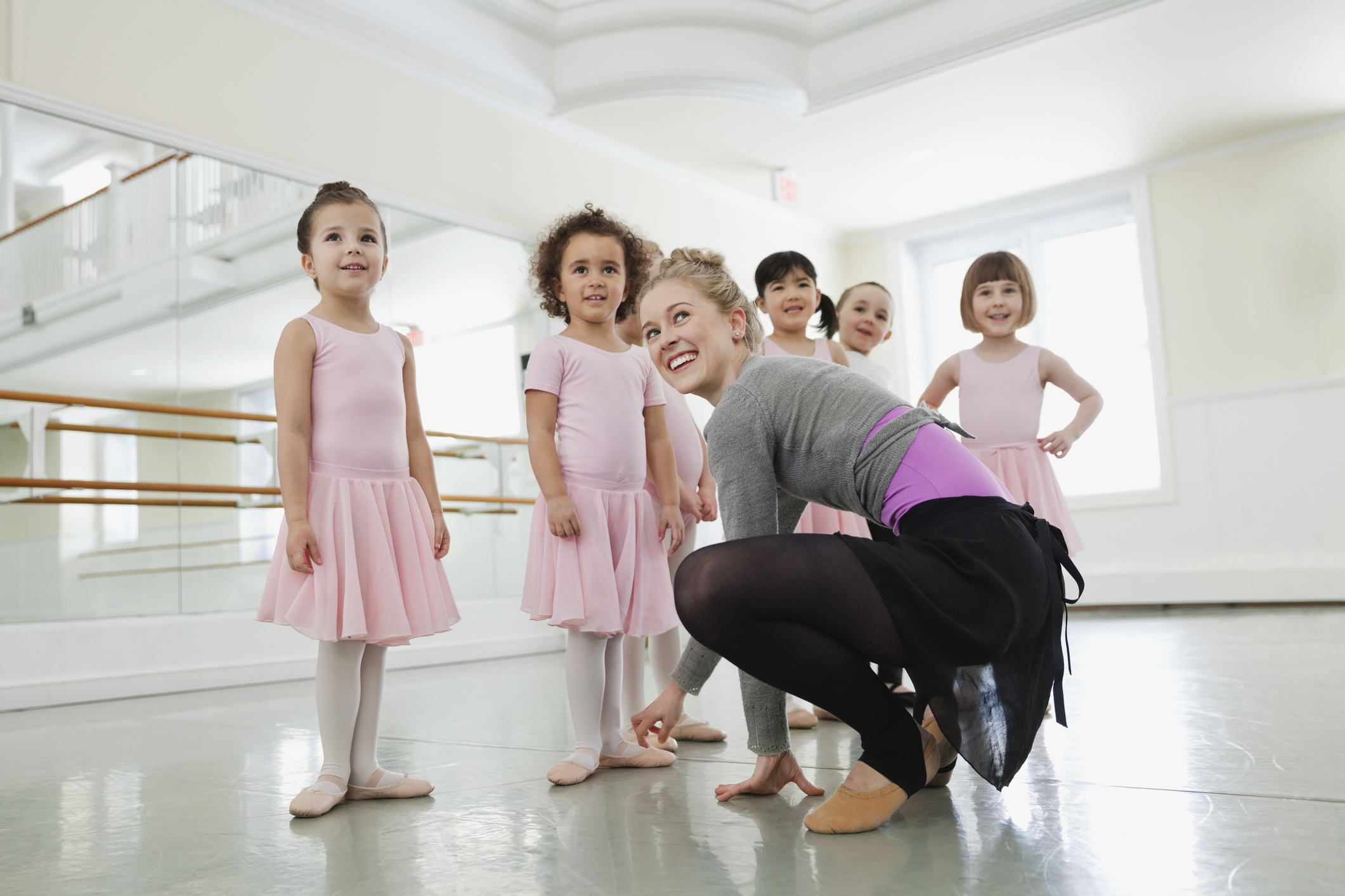 Female ballet instructor teaching children in ballet studio