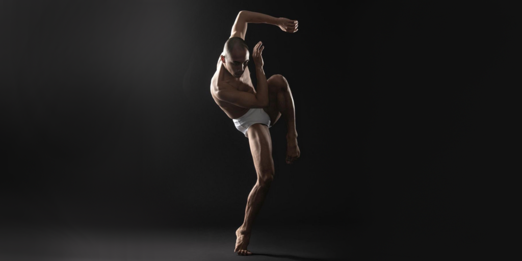 Kevin Pajarillaga wearing briefs mid movement against a dark background.