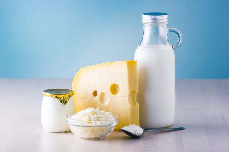 Milk, cheese, and yogurt sit against a blue background.