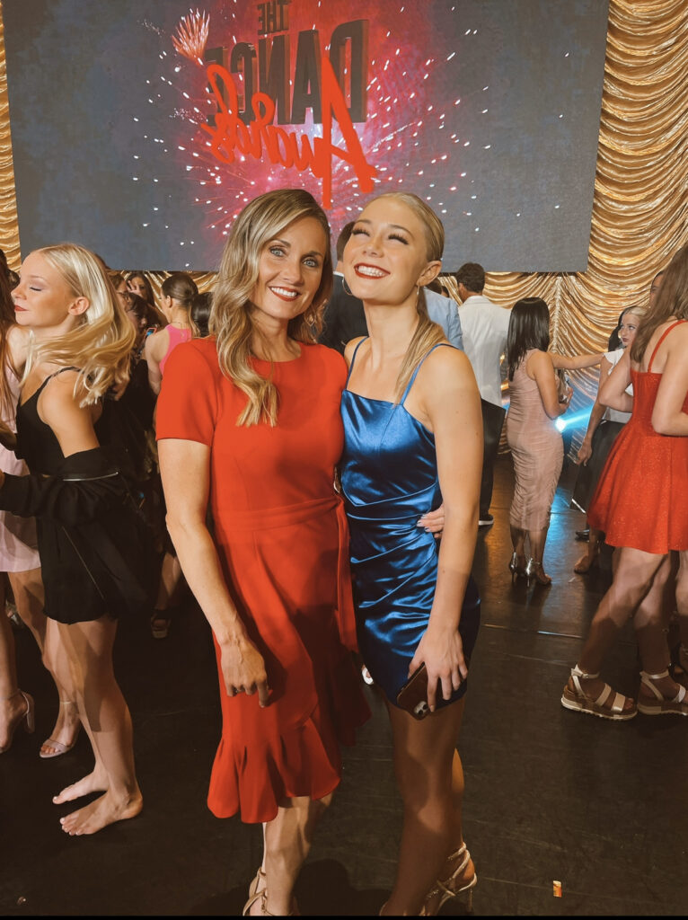 At a convention, Hailey and Stacy Bills pose for a photo together in long evening-wear gowns.