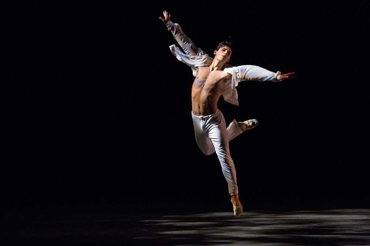 Ariel Rose dressed in white pants and a white open shirt performing in Sweet Fields by Twyla Tharp.