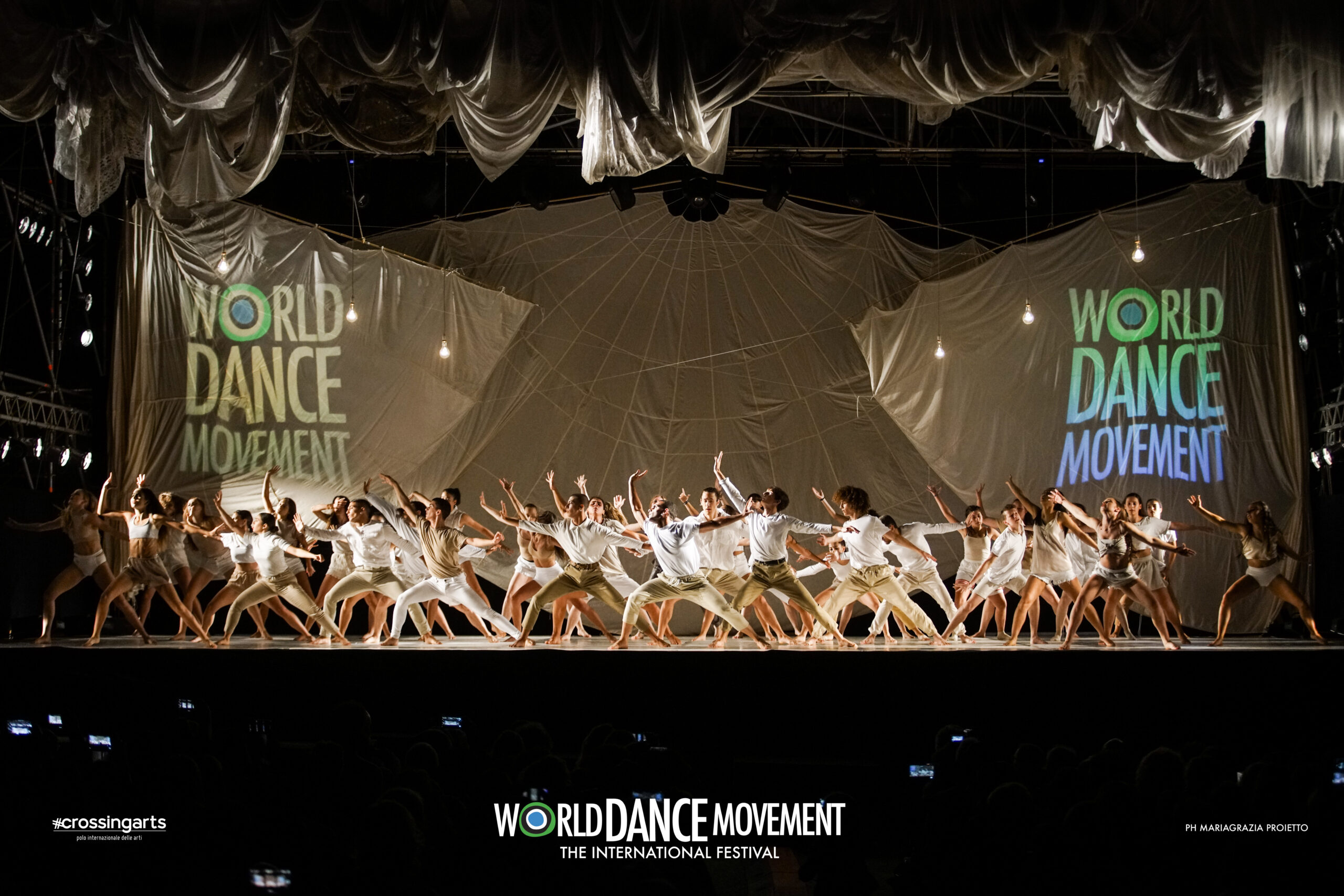 Group of dancers wearing white on stage at World Dance Movement.