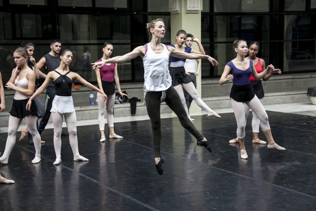 Helen Crawford (airborne in a jump) teaching a group of ballet students.