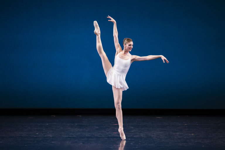 Ballet West Principal Artist Emily Adams wearing a white costume on stage in CONCERTO BAROCCO.