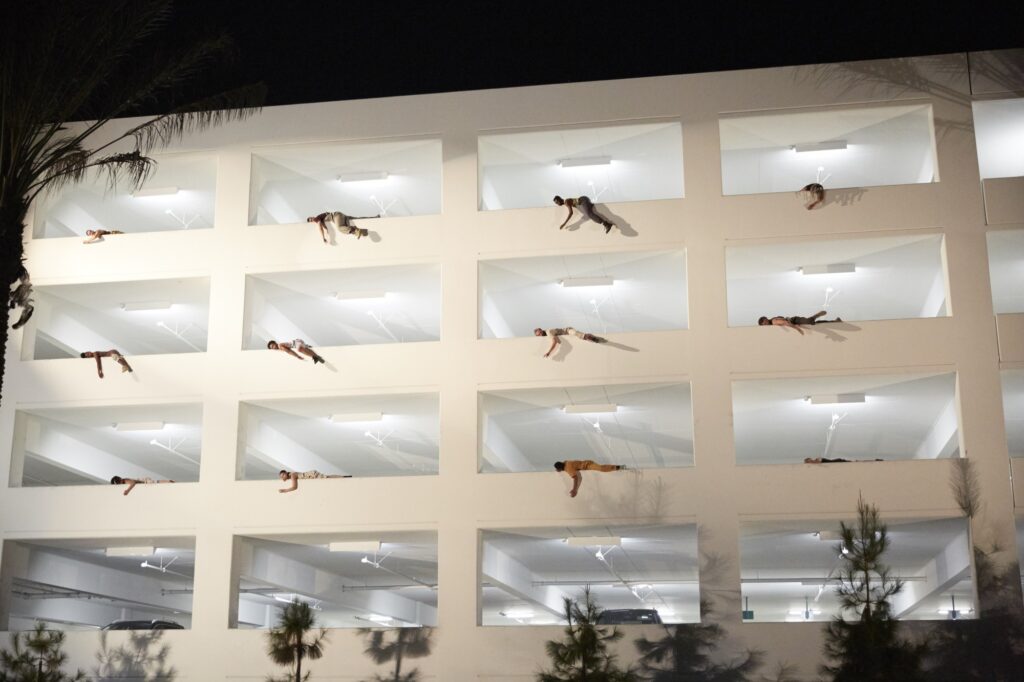 Dancers lying on the walls of a parking lot