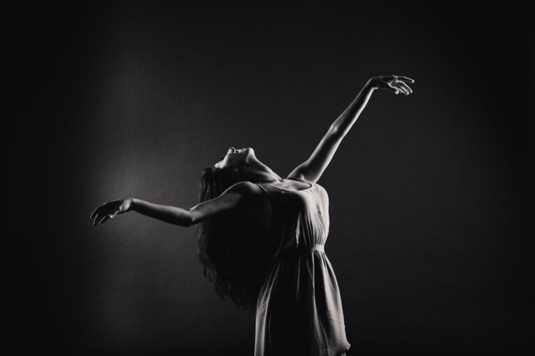 Black and white image of graceful dancer arching her back.