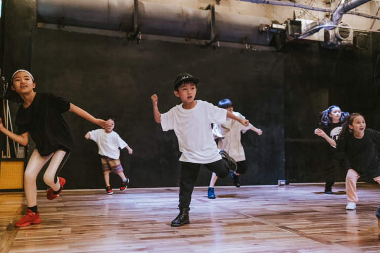 Kids of various ages engage in a hip-hop breakdance session.