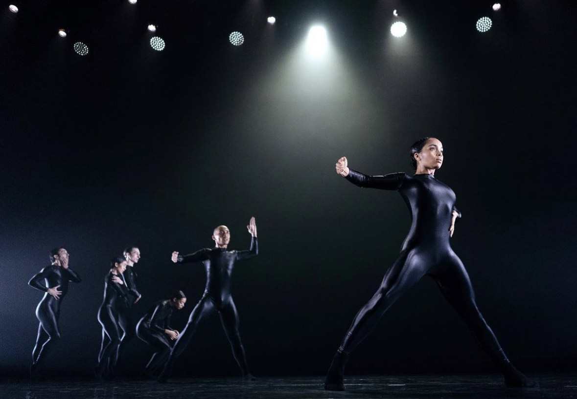 Miriam Gittens performing in a black costume on stage.