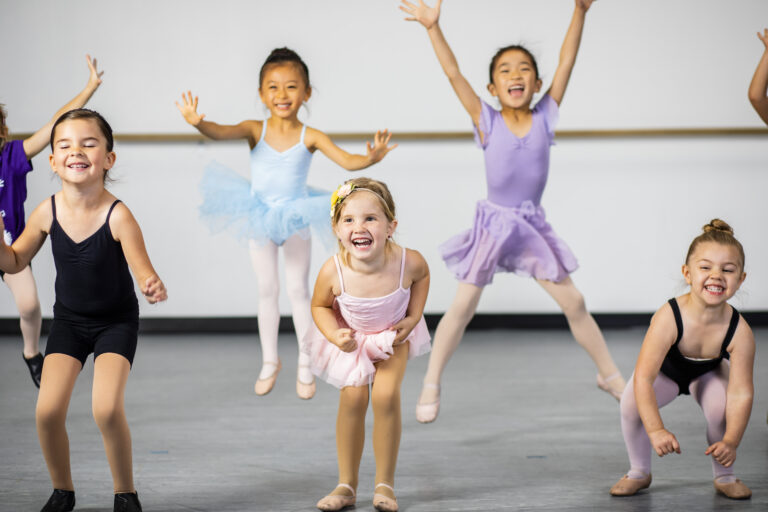 A diverse young group of students practice in musical theatre and ballet combo dance class