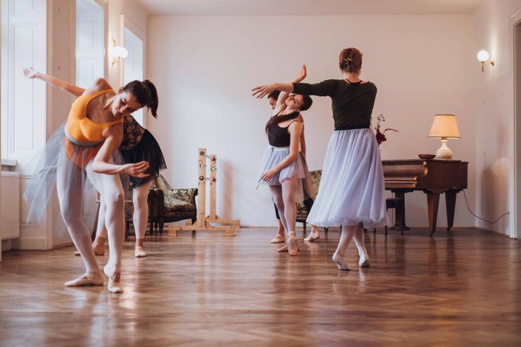 Four ballet students improvising in a studio.
