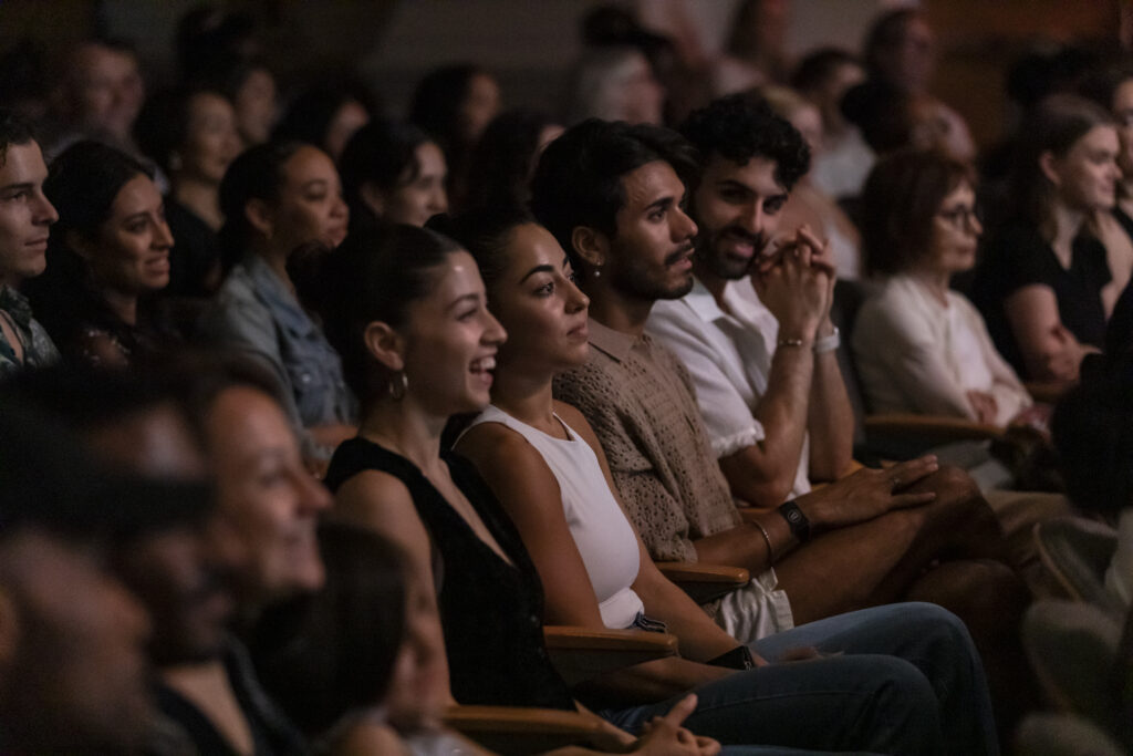 Audience members seated at a theater.