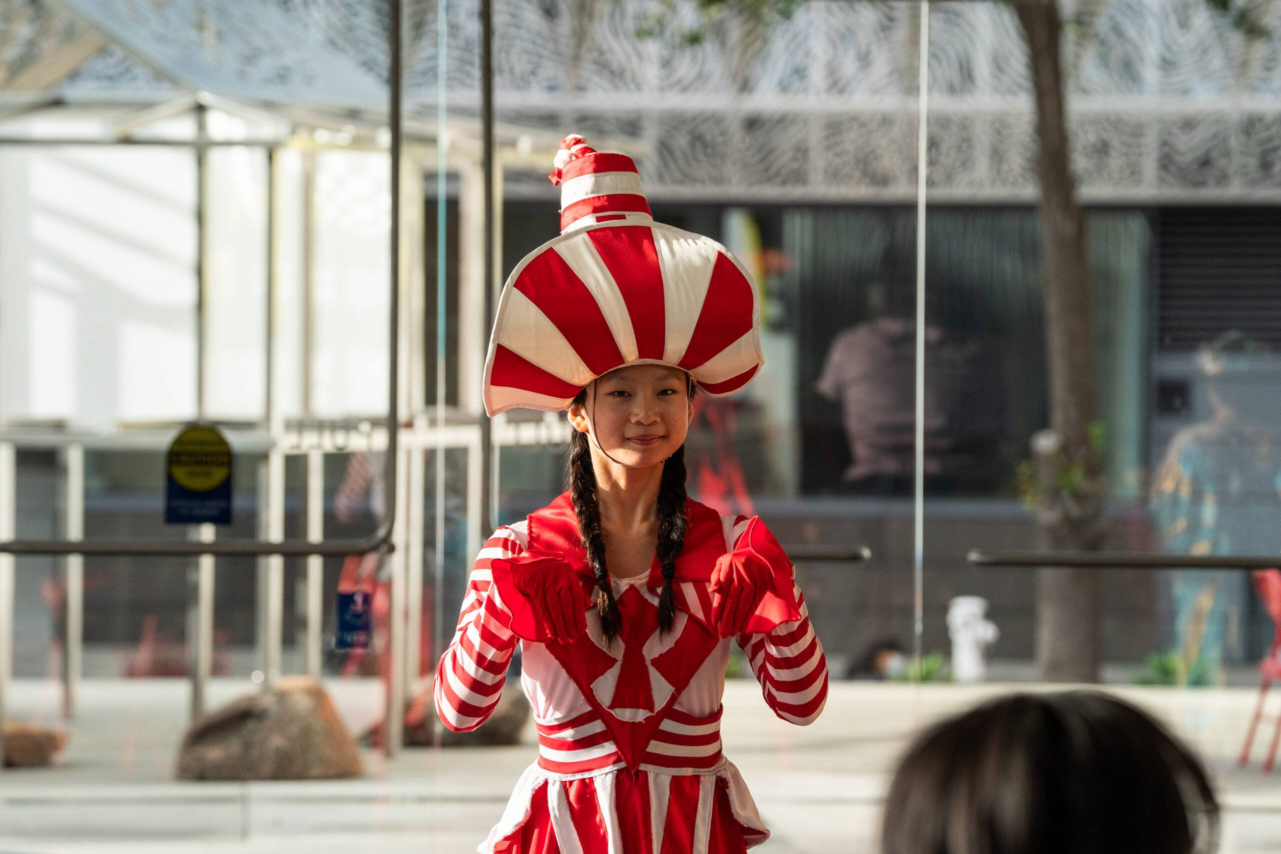 Image of a dancer dressed as a candy cane in red and white costume.