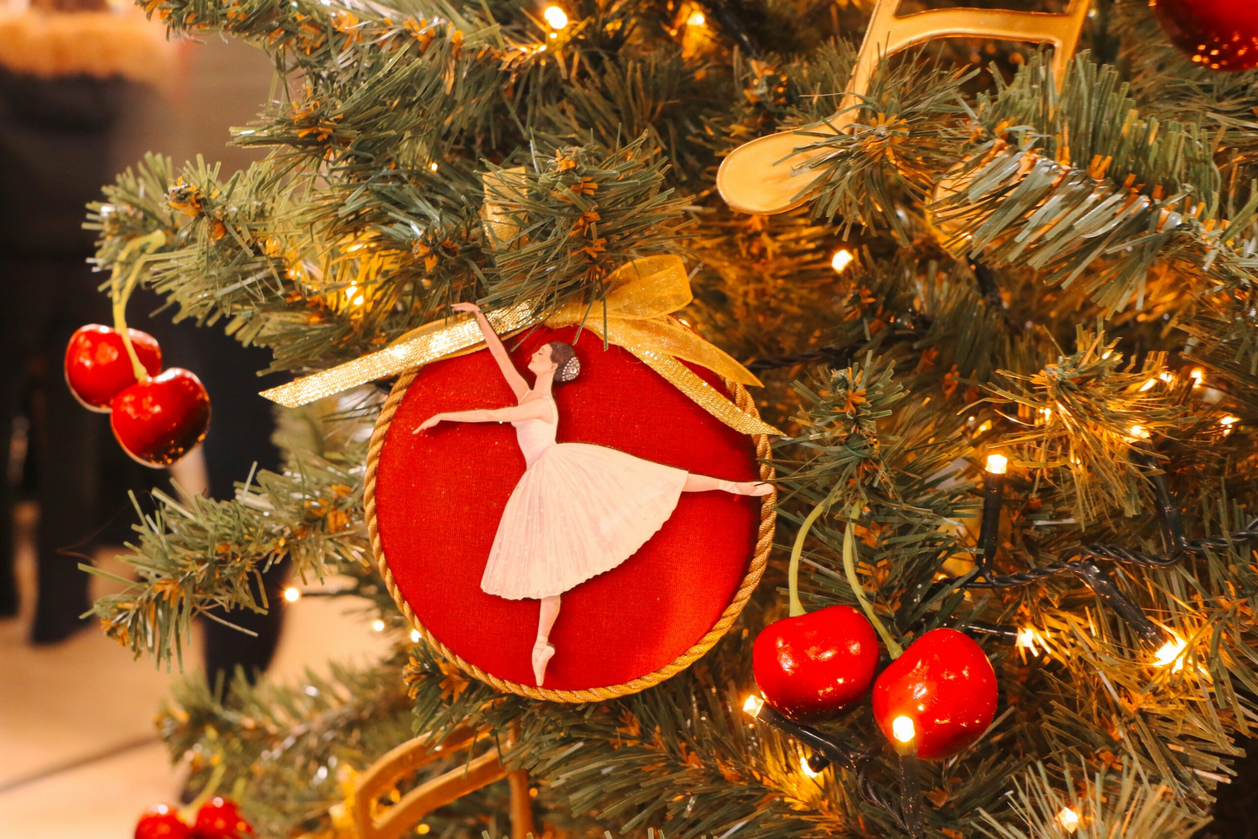 Ballerina ornament against a christmas tree.