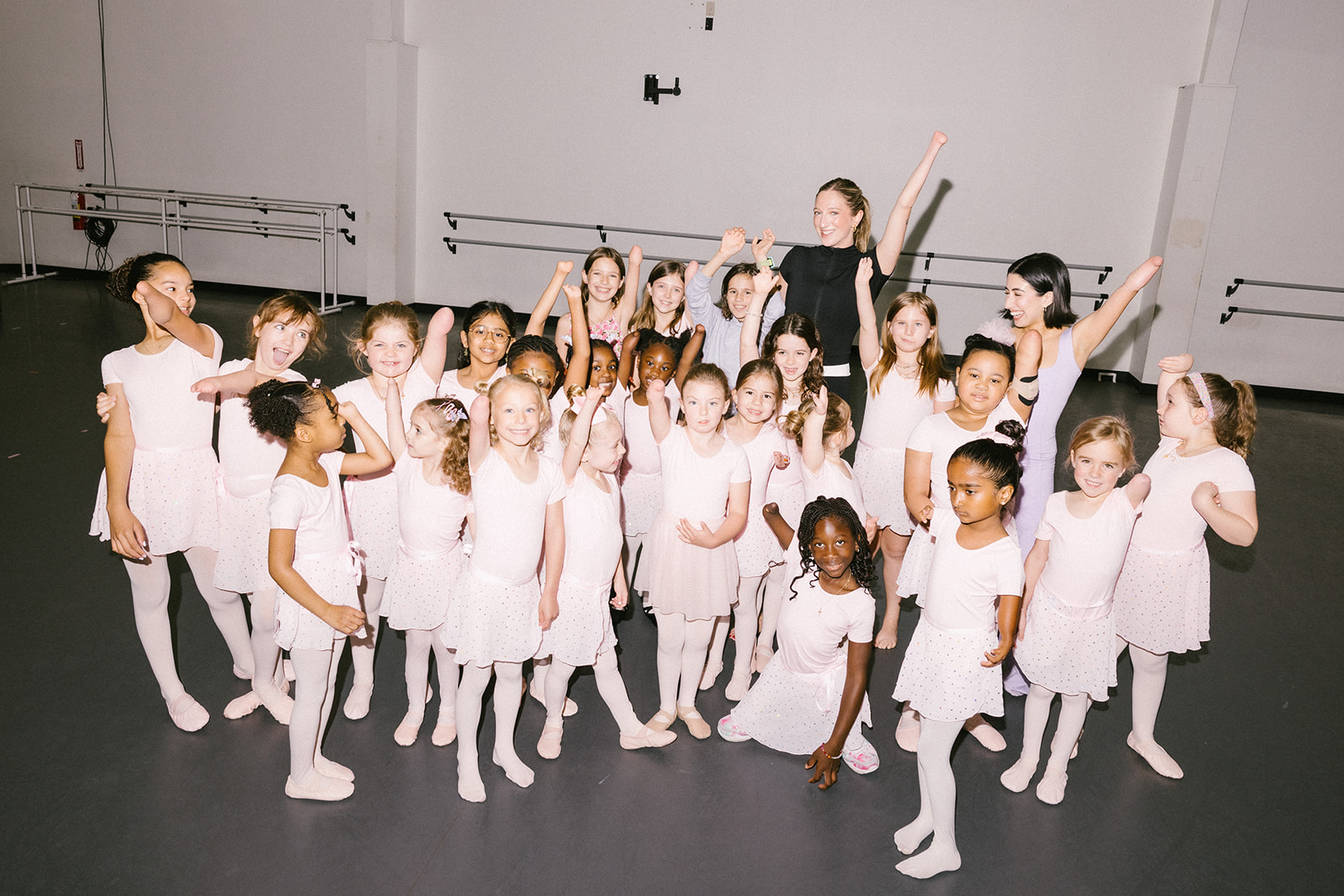 Group photo of Sydney Mesher with young dancers with limb differences dressed in ballet oufits.