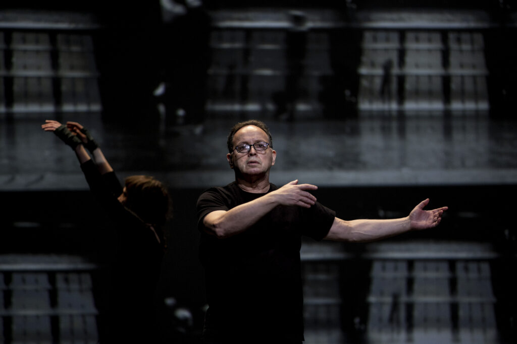 Zvi Gotheiner teaching in a dark-lit rehearsal space.