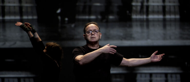 Zvi Gotheiner teaching in a dark-lit rehearsal space.