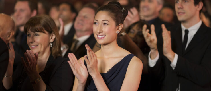 Audience clapping in a theater.