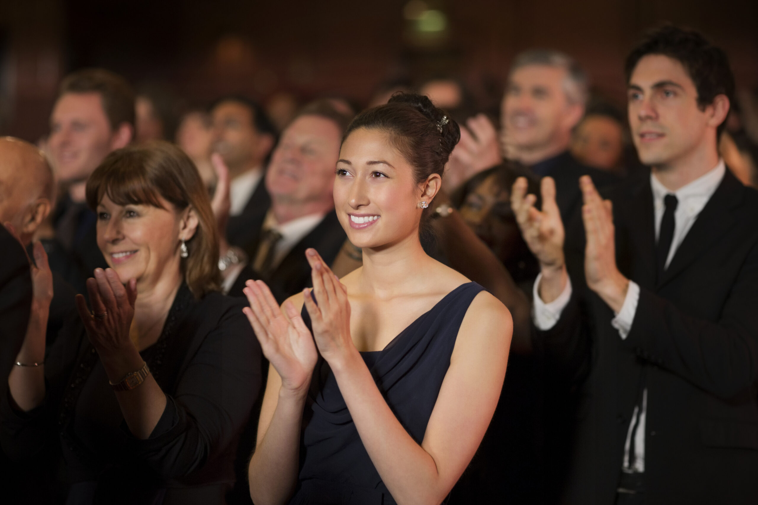 Audience clapping in a theater.